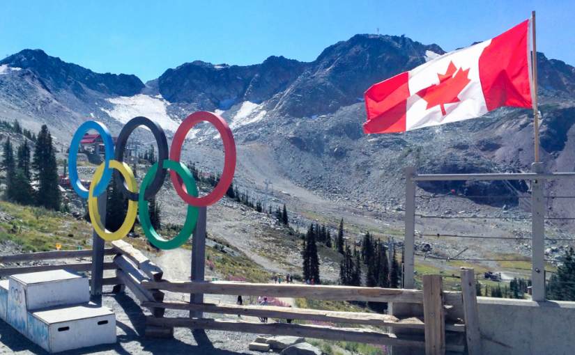写真：ウィスラー山の上、オリンピックのモニュメントとカナダ国旗がある