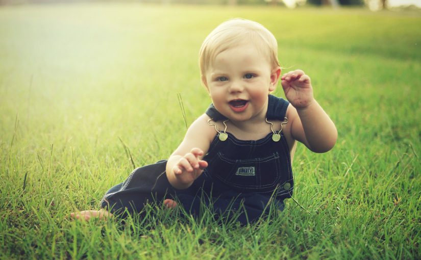 写真：草原で赤ちゃんが笑っている様子