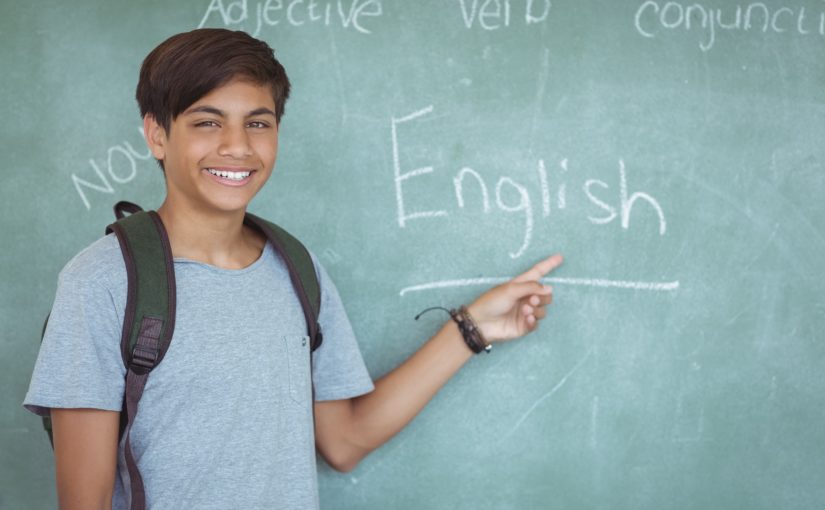 写真：男の子が黒板に書いてあるEnglishを指差している様子