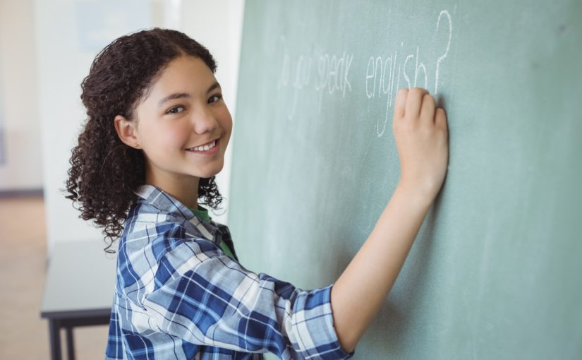 写真：女の子が黒板に英語を書いている様子